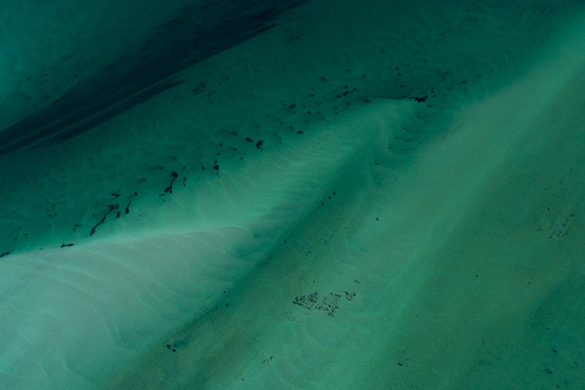 Aerial view of turquoise ocean water with intricate sand patterns and ripples in the Shire of Shark Bay Western Australia Australia. Aerial view of turquoise ocean water with intricate sand patterns and ripples in the Shire of Shark Bay Western Australia Australia.
