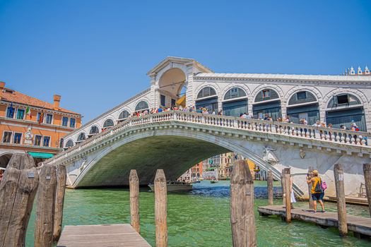 Venice Italy 29 March 2026 View of the Rialto Bridge its white stone gleaming under the clear sky bustling with people against the backdrop of aged buildings. Venice Italy 29 March 2026 View of the Rialto Bridge its white stone gleaming under the clear sky bustling with people against the backdrop of aged buildings.