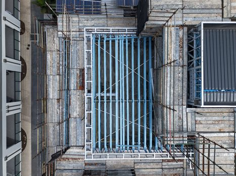 Aerial view of a construction site featuring intricate scaffolding and exposed steel beams on an industrial building in Melbourne VIC Australia.