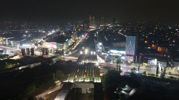 Aerial view of the illuminated urban landscape and elevated highway construction project at night in Bekasi Barat West Java Indonesia. Aerial view of the illuminated urban landscape and elevated highway construction project at night in Bekasi Barat West Java Indonesia.
