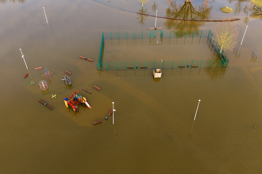 Aerial view of a flooded playground and sports court with murky water covering benches and lamp posts in Kedainiai Kaunas County Lithuania. Aerial view of a flooded playground and sports court with murky water covering benches and lamp posts in Kedainiai Kaunas County Lithuania.