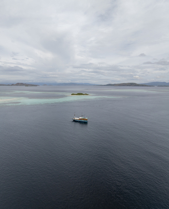 Aerial view of a traditional wooden boat sailing in the turquoise waters near Komodo Island Komodo East Nusa Tenggara Indonesia.