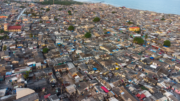 Aerial view of the dense urban landscape of Teshie with closely packed rooftops and narrow streets stretching towards the coastline in Accra Greater Accra Region Ghana.