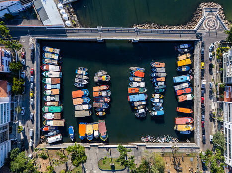 Aerial view of Quadrado da Urca marina with colorful boats moored in rows within the harbor surrounded by urban streets and trees in Rio de Janeiro Rio de Janeiro Brazil.