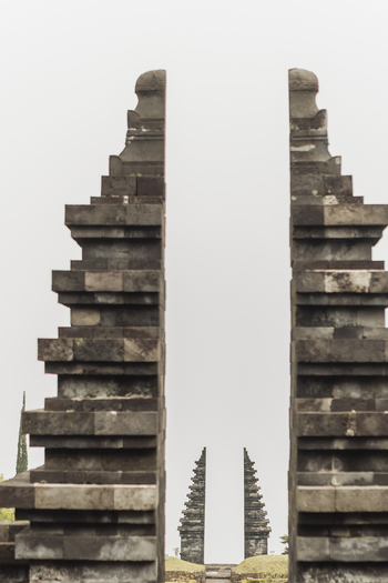 View of the iconic split gateway of Cetho Temple with its traditional stone masonry under a misty sky in Kecamatan Jenawi Jawa Tengah Indonesia. View of the iconic split gateway of Cetho Temple with its traditional stone masonry under a misty sky in Kecamatan Jenawi Jawa Tengah Indonesia.