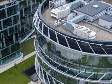 Aerial view of a modern office building featuring rooftop HVAC cooling systems and glass facade in Krakow Lesser Poland Voivode Poland.