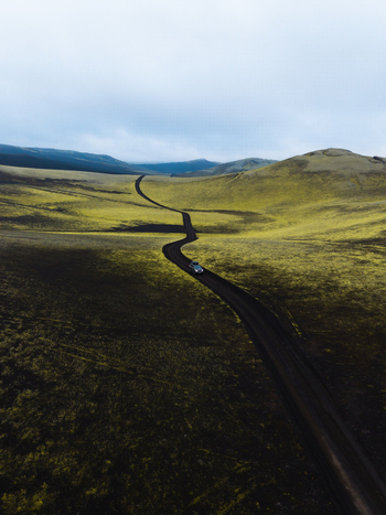 Aerial view of a winding road cutting through the vast moss covered landscape under a brooding sky Iceland. Aerial view of a winding road cutting through the vast moss covered landscape under a brooding sky Iceland.