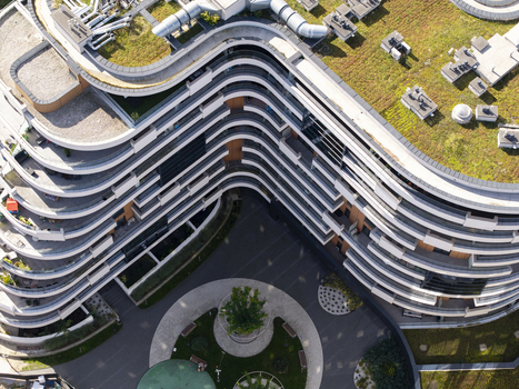 Aerial view of a modern residential building with curved balconies and green roofs surrounding a landscaped courtyard in Krakow Lesser Poland Voivode Poland.