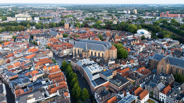 Aerial view of the historic city center of Zwolle featuring the Grote of Sint Michaelskerk dense red tiled rooftops narrow streets and green trees in Zwolle Overijssel Netherlands.