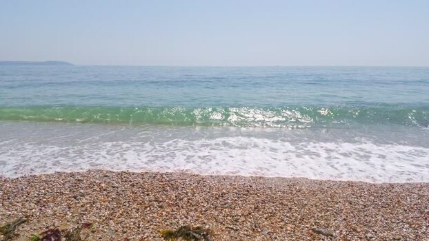 View of waves on the pebble beach in Charlestown United Kingdom. View of waves on the pebble beach in Charlestown United Kingdom.