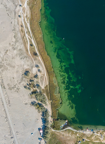 Aerial view of Blind Lake Sarfaranga Shigar with its vibrant green waters meeting the sandy shoreline and dirt tracks in Skardu Gilgit Pakistan. Aerial view of Blind Lake Sarfaranga Shigar with its vibrant green waters meeting the sandy shoreline and dirt tracks in Skardu Gilgit Pakistan.