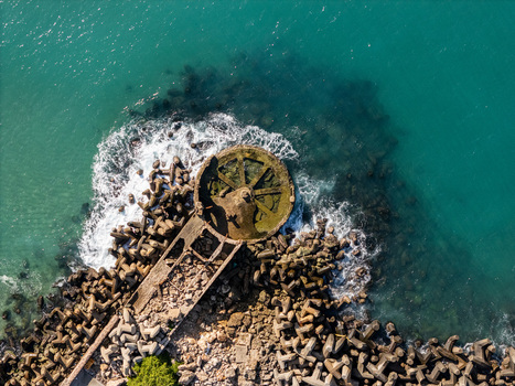 Aerial view of the coastal breakwater structure at the mouth of the Rio Ozama featuring concrete tetrapods and turquoise Caribbean sea water in Santo Domingo Santo Domingo Dominican Republic.