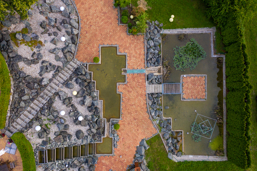 Aerial view of a modern landscaped garden with red brick paths stone rockeries and tranquil water ponds Forchheim Bavaria Germany.