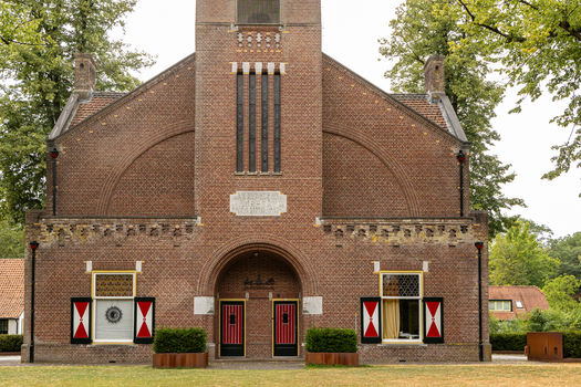 View of De Brandtoren a historic brick building with distinctive red and white shutters and arched entrance located in Esbeek Noord Brabant Netherlands.