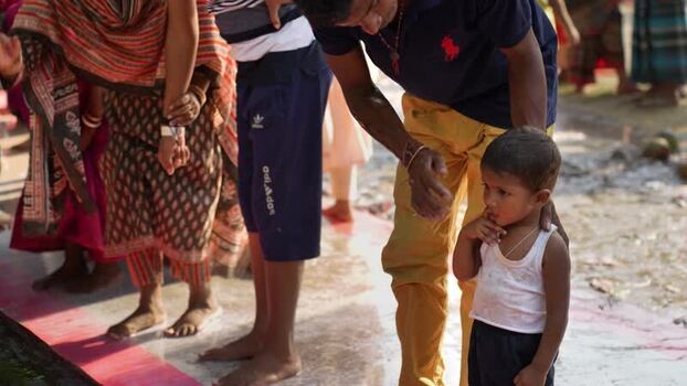 View of a man caring for a young child in Pabna Bangladesh. View of a man caring for a young child in Pabna Bangladesh.