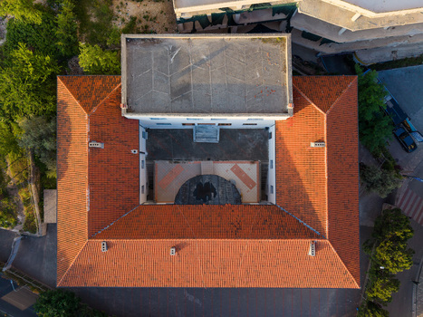 Aerial view of a historic building with a red tiled roof and a central courtyard surrounded by lush greenery in Kruje Durres County Albania.