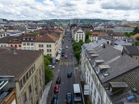Aerial view of urban street with cars and historic buildings under a cloudy sky in Biel Bienne Canton of Bern Switzerland. Aerial view of urban street with cars and historic buildings under a cloudy sky in Biel Bienne Canton of Bern Switzerland.