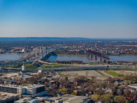 Aerial view of the Abraham Lincoln Bridge and Big Four Bridge crossing the Ohio River with the urban landscape and highways in Louisville Kentucky United States.