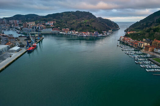 Pasai Donibane Spain 10 March 2026 Aerial view of the Harbour mouth of Pasaia with its narrow channel coastal buildings and lush green hills under a cloudy sky. Pasai Donibane Spain 10 March 2026 Aerial view of the Harbour mouth of Pasaia with its narrow channel coastal buildings and lush green hills under a cloudy sky.