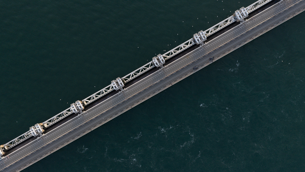 Aerial view of the Eastern Scheldt Storm Surge Barrier spanning across the dark blue waters of the Oosterschelde estuary. Vrouwenpolder Zeeland Netherlands. Aerial view of the Eastern Scheldt Storm Surge Barrier spanning across the dark blue waters of the Oosterschelde estuary. Vrouwenpolder Zeeland Netherlands.