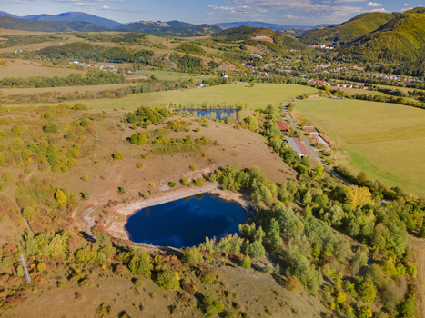 Aerial view of the Gudronove jamy acid tar lagoons surrounded by rolling hills and autumn foliage near the Low Tatras mountains in Predajna Banskobystricky kraj Slovakia. Aerial view of the Gudronove jamy acid tar lagoons surrounded by rolling hills and autumn foliage near the Low Tatras mountains in Predajna Banskobystricky kraj Slovakia.