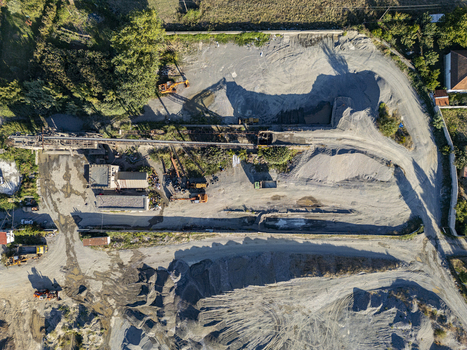 Aerial view of a gravel and sand quarry site with heavy machinery piles of aggregate and industrial equipment located near Rruga Katalines in Bahcallek Shkoder County Albania.