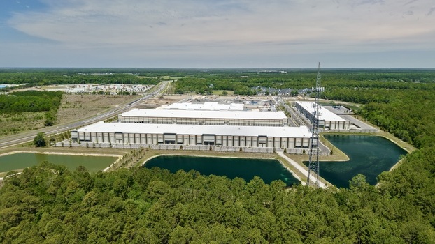 Aerial view of large industrial warehouses with white rooftops surrounded by lush green forests and retention ponds at World Golf Village Florida United States. Aerial view of large industrial warehouses with white rooftops surrounded by lush green forests and retention ponds at World Golf Village Florida United States.