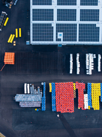 Aerial view of an industrial facility featuring solar panels on the roof and organized stacks of colorful polymer pipes in the yard in Jelgava Latvia. Aerial view of an industrial facility featuring solar panels on the roof and organized stacks of colorful polymer pipes in the yard in Jelgava Latvia.