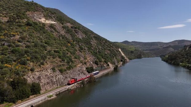 Aerial view of train near river and hills in Douro valley UNESCO site Portugal. Aerial view of train near river and hills in Douro valley UNESCO site Portugal.