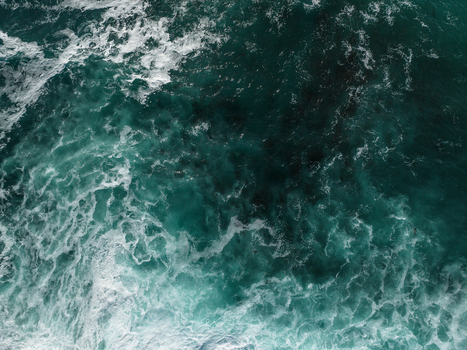 Aerial view of turquoise ocean waves crashing with white foam and dark kelp visible beneath the surface at La Jolla Cove in San Diego California United States. Aerial view of turquoise ocean waves crashing with white foam and dark kelp visible beneath the surface at La Jolla Cove in San Diego California United States.