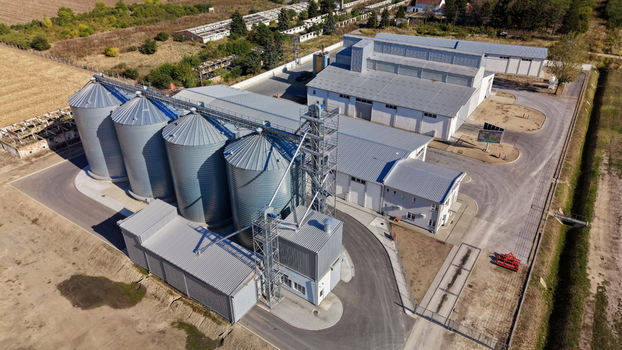 Aerial view of the storage silo Bavaniste facility featuring large metal grain silos and industrial buildings surrounded by agricultural fields in Bavaniste Vojvodina Serbia.