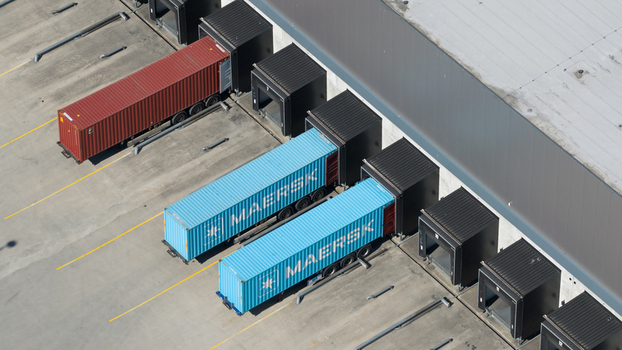 Rotterdam Netherlands 01 May 2026 Aerial view of Maersk shipping containers docked at a modern warehouse loading bay with concrete pavement and industrial infrastructure. Rotterdam Netherlands 01 May 2026 Aerial view of Maersk shipping containers docked at a modern warehouse loading bay with concrete pavement and industrial infrastructure.