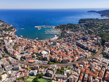 Aerial view of the coastal town of Rapallo featuring the harbor colorful buildings and railway line along the Mediterranean coast in Rapallo Liguria Italy. Aerial view of the coastal town of Rapallo featuring the harbor colorful buildings and railway line along the Mediterranean coast in Rapallo Liguria Italy.