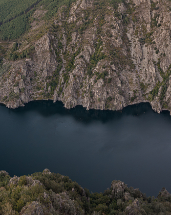 Aerial view of Ribeira Sacra canyon with steep rocky cliffs and deep river waters in Lugo Galicia Spain. Aerial view of Ribeira Sacra canyon with steep rocky cliffs and deep river waters in Lugo Galicia Spain.