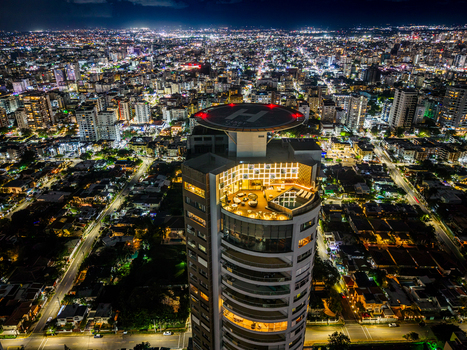 Santo Domingo Dominican Republic 20 September 2026 Aerial view of the illuminated Caney Tower with its rooftop helipad and swimming pool overlooking the city at night.