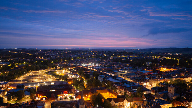 Aerial view of the city of Salisbury at twilight with glowing street lights illuminating the historic rooftops and urban landscape in Salisbury Wiltshire United Kingdom. Aerial view of the city of Salisbury at twilight with glowing street lights illuminating the historic rooftops and urban landscape in Salisbury Wiltshire United Kingdom.