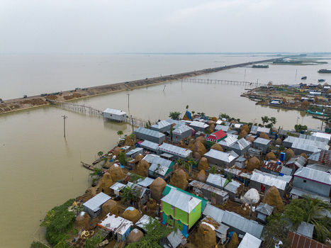 Mithamain Bangladesh 10 September 2025 Aerial view of Mithamain village featuring corrugated metal roofs and haystacks surrounded by floodwaters in the haor region. Mithamain Bangladesh 10 September 2025 Aerial view of Mithamain village featuring corrugated metal roofs and haystacks surrounded by floodwaters in the haor region.