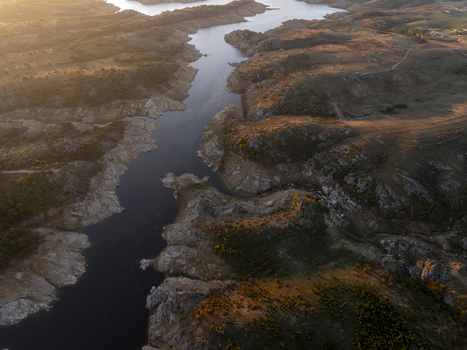Aerial view of a winding river reservoir surrounded by rugged hills and rocky terrain under the warm light of the golden hour in Kirklareli Merkez Turkiye. Aerial view of a winding river reservoir surrounded by rugged hills and rocky terrain under the warm light of the golden hour in Kirklareli Merkez Turkiye.