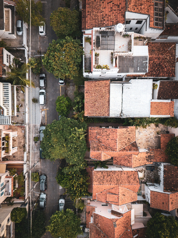 Aerial view of the Urca neighborhood featuring traditional red clay rooftops lush green trees and parked cars along a narrow street in Rio de Janeiro State of Rio de Janeiro Brazil. Aerial view of the Urca neighborhood featuring traditional red clay rooftops lush green trees and parked cars along a narrow street in Rio de Janeiro State of Rio de Janeiro Brazil.
