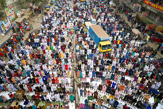 Tongi Bangladesh 31 January 2025 Aerial view of Tongi Ijtema Maidan with a large crowd of Muslim men gathered for prayer in the streets surrounded by urban buildings.
