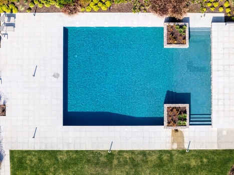 Aerial view of a modern rectangular swimming pool with turquoise water stone decking and integrated planters in Cascais Lisboa Portugal. Aerial view of a modern rectangular swimming pool with turquoise water stone decking and integrated planters in Cascais Lisboa Portugal.
