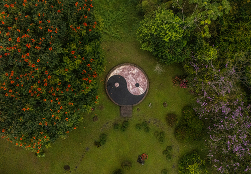 Aerial view of a Yin Yang symbol in a lush garden surrounded by flowering trees and vibrant greenery in Cinchona Alajuela Province Costa Rica. Aerial view of a Yin Yang symbol in a lush garden surrounded by flowering trees and vibrant greenery in Cinchona Alajuela Province Costa Rica.