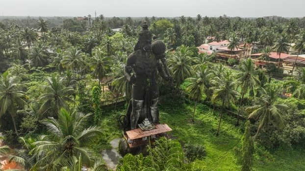 Aerial view of the large Hanuman statue surrounded by lush palm trees and tropical greenery in Udupi Karnataka India. Aerial view of the large Hanuman statue surrounded by lush palm trees and tropical greenery in Udupi Karnataka India.