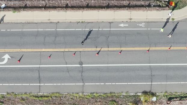 Aerial view of road with people and traffic cones in United States. Aerial view of road with people and traffic cones in United States.