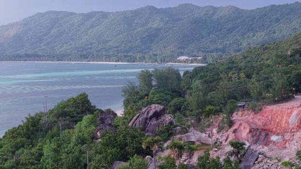 Aerial view of Praslin coastline and lush hills in Seychelles.