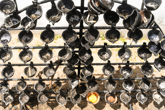 View of rows of traditional black oil lamps on a metal rack at the Japanese Peace Pagoda Rumassala in Unawatuna Southern Province Sri Lanka. View of rows of traditional black oil lamps on a metal rack at the Japanese Peace Pagoda Rumassala in Unawatuna Southern Province Sri Lanka.