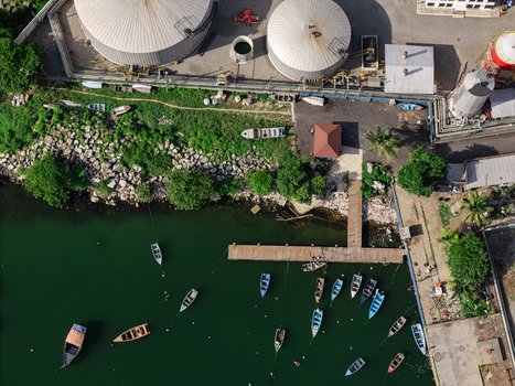 Aerial view of the industrial port in Bajos de Haina with storage tanks a wooden pier and fishing boats moored in the harbor Bajos de Haina San Cristobal Province Dominican Republic.
