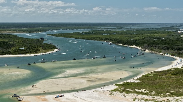 Aerial view of Matanzas Inlet featuring turquoise water sandy shoals numerous recreational boats and lush coastal vegetation in St. Johns County Florida United States. Aerial view of Matanzas Inlet featuring turquoise water sandy shoals numerous recreational boats and lush coastal vegetation in St. Johns County Florida United States.