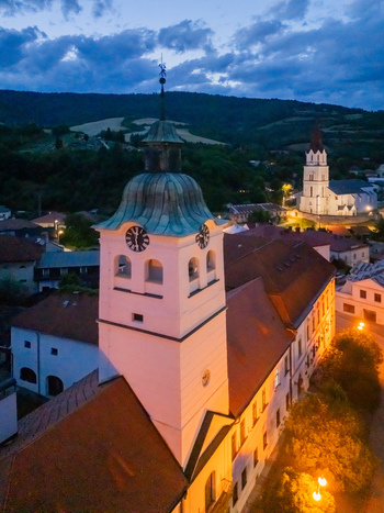 Aerial view of the illuminated St. Cross Church and tower stand majestically against the twilight a beacon amidst the town s embrace Gelnica Kosice Region Slovakia. Aerial view of the illuminated St. Cross Church and tower stand majestically against the twilight a beacon amidst the town s embrace Gelnica Kosice Region Slovakia.