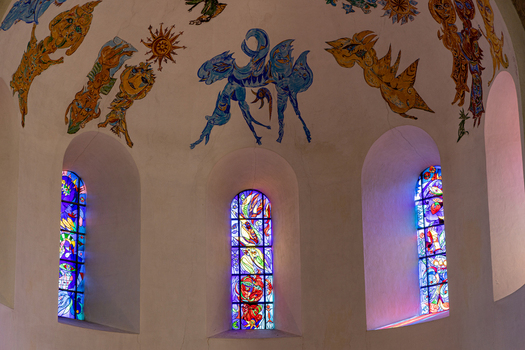 View of the modern stained glass windows and colorful ceiling murals by Carl Henning Pedersen inside the historic Ribe Cathedral in Ribe Denmark. View of the modern stained glass windows and colorful ceiling murals by Carl Henning Pedersen inside the historic Ribe Cathedral in Ribe Denmark.